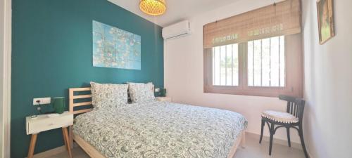 a bedroom with a bed and a blue wall at Vista al Mar 2 Peñiscola in Peniscola