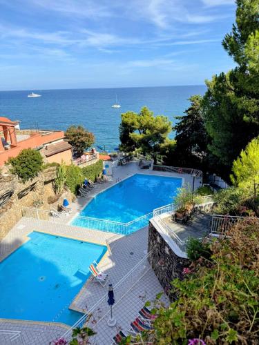 an overhead view of a swimming pool next to the ocean at Residenza Madea - Vista Mare, Piscina, Spiaggia Privata e Parcheggio in Marina di Andora