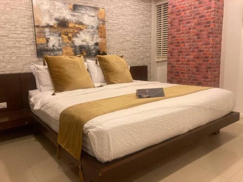 a large bed in a room with a brick wall at Apartment Eliza Samui in Garden Resort with Shared Pool in Plai Laem