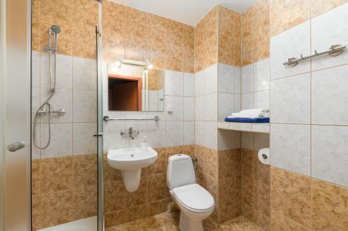 a bathroom with a toilet and a sink and a shower at San Medical Spa in Kołobrzeg