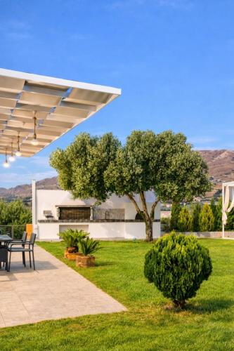 a patio with a table and a tree at 500 sqm Private Garden, Outdoor Kitchen, near Falasarna & Balos Beach in Falasarna