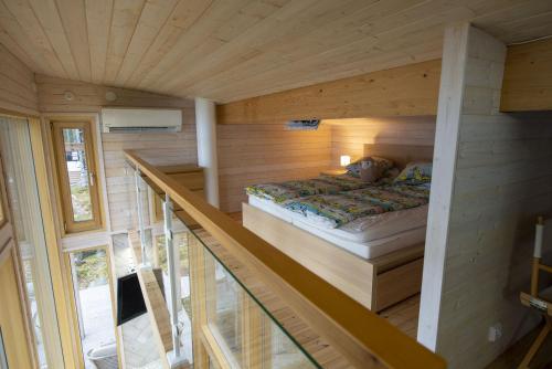 a bedroom with a bed in a wooden wall at Rantarovio in Alvajärvi