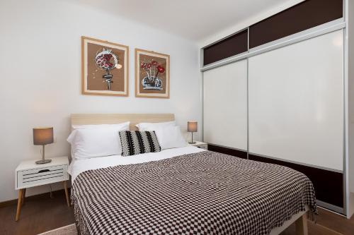 a bedroom with a bed with a black and white blanket at Apartment Lassy by Irundo in Rovinj