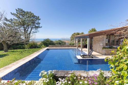 a swimming pool in the yard of a house at Carreços Beach Farm in Viana do Castelo