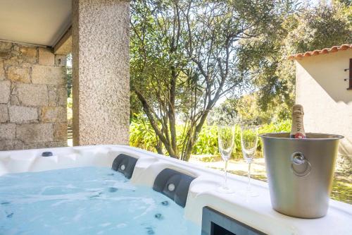 a hot tub with wine glasses and a bucket at Carreços Beach Farm in Viana do Castelo