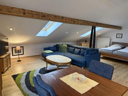 a living room with a blue couch and a table at Ferienwohnung Scheibenwand-Loft in Aschau im Chiemgau