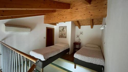 two beds in a small room with wooden ceilings at Bombyx Inn in Bergamo