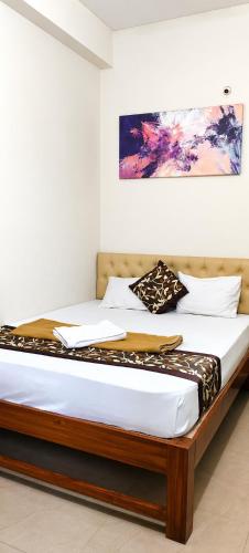 a bed in a room with a painting on the wall at Hotel Mayur Lodge in Bijāpur