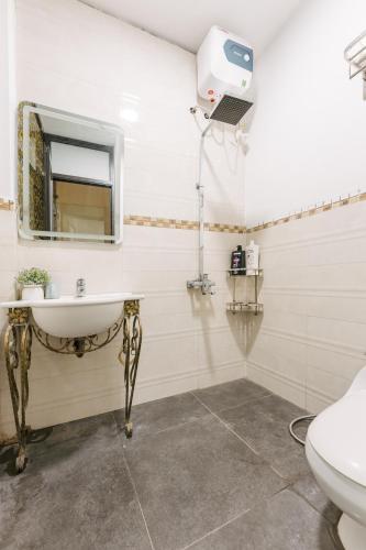 a bathroom with a sink and a mirror and a toilet at Supper Location City view 3Br 5CG in Hanoi
