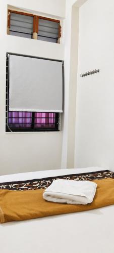 a bed in a room with a window at Hotel Mayur Lodge in Bijāpur