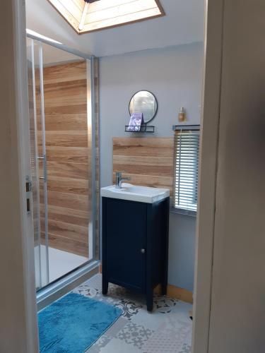 a bathroom with a sink and a shower with a mirror at The Old Forge in La Ressière