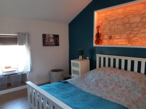 a bedroom with a bed and a blue wall at The Old Forge in La Ressière