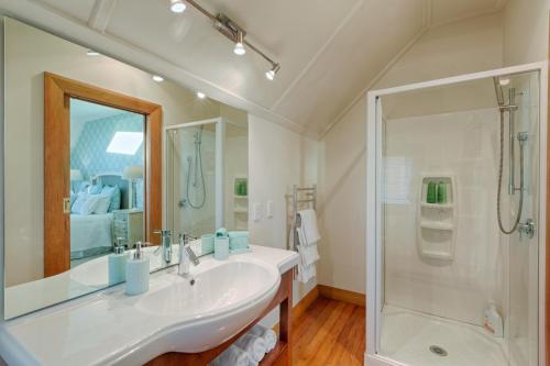 a white bathroom with a sink and a shower at The Terrace - Luxury Villa in the heart of Oamaru in Oamaru