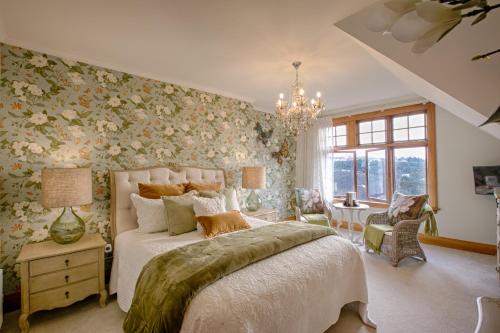a bedroom with a large bed with floral wallpaper at The Terrace - Luxury Villa in the heart of Oamaru in Oamaru