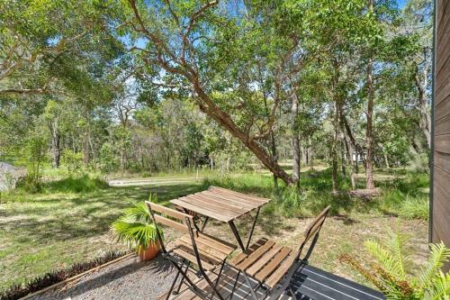 a picnic table and two chairs in a yard at Wildlife Haven by Tiny Away in Agnes Water