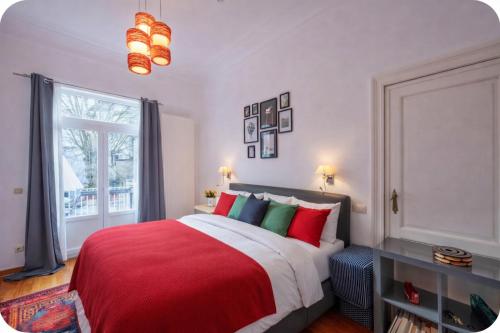 a bedroom with a bed with red and green pillows at Euro Edens Brussels - Family Home & Free Gym Access in Brussels