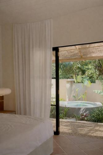 a bedroom with a bed and a window at Design Cabin with Plunge Pool in Ahangama