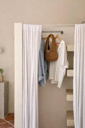 a closet with white curtains and a rack of clothes at Design Cabin with Plunge Pool in Ahangama