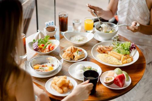 a group of people sitting around a table with food at DoubleTree by Hilton Sukhumvit Bangkok in Bangkok