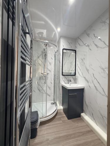 a bathroom with a shower and a sink and a tub at The Villas holiday homes in Horden