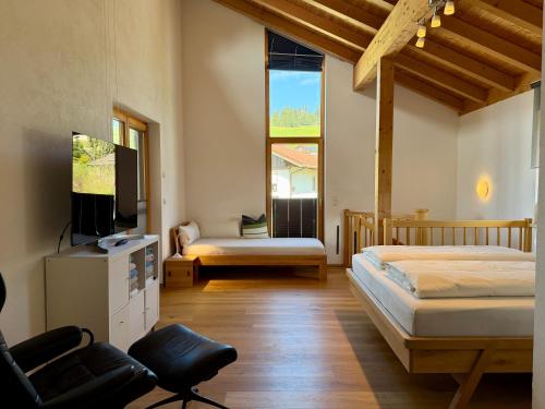 a bedroom with two beds and a flat screen tv at Ferienwohnung Richter in Rettenberg