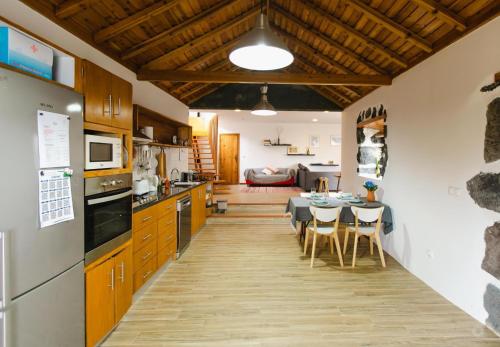 a kitchen and dining room with a table and chairs at Casa da Petra in Urzelina