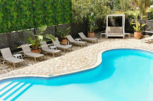 a swimming pool with chaise lounge chairs next to a patio at King's Holiday Apartments in Paphos