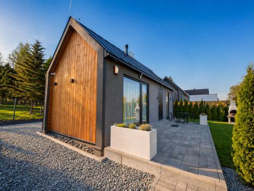 a house with a large wooden door and a patio at Domek A - domki w górach z prywatnym SPA - 4 seasons lodges Ustroń in Ustroń
