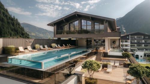a house with a swimming pool on top of a building at Neuhaus Zillertal Resort in Mayrhofen
