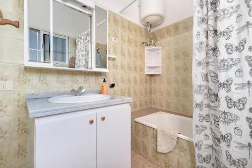 a bathroom with a sink and a tub and a shower curtain at Finca El Pizarro in Arico