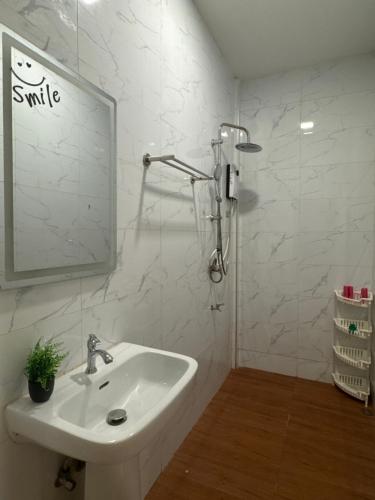 a white bathroom with a sink and a mirror at Cozy Clover house in Hat Yai
