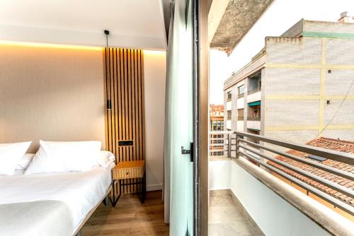 a bedroom with a bed and a balcony at Centrotel Zamora in Zamora