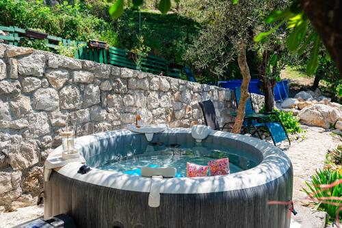 a hot tub in front of a stone wall at Dream View Villa in Kotor