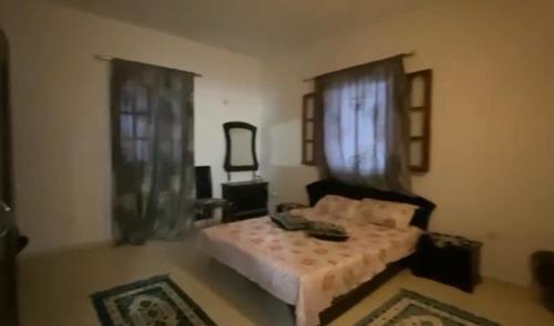 a bedroom with a bed and a window and a mirror at Ali yessine in Al Maqārisah
