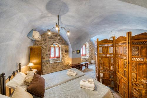 a bedroom with a large bed and a stone wall at Mesaionas 2 in Olýmpoi