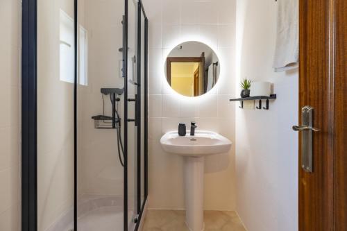 a white bathroom with a sink and a mirror at Beachfront Rental Home & Sea Views by Invalencia in Sagunto