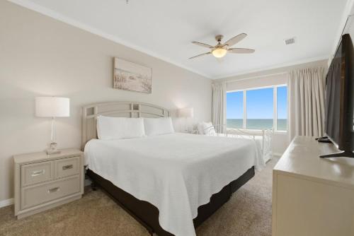 a white bedroom with a bed and a window at Marlin Key 2A in Orange Beach