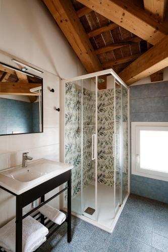 a bathroom with a glass shower and a sink at Villa Bido in Anguillara Veneta