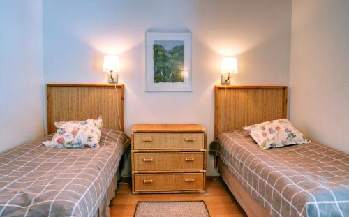 a bedroom with two beds and two lamps on the wall at Katinkulta Apartments in Vuokatti