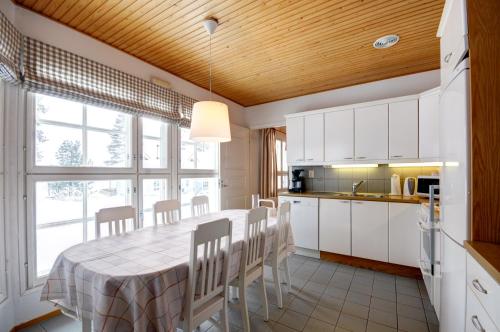 een keuken met een tafel en stoelen in een kamer bij Katinkulta Apartments in Vuokatti