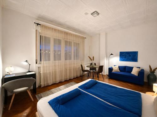 a bedroom with a blue bed and a blue couch at Buda Blue in Budapest