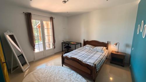 a bedroom with a bed and a mirror and a window at Villa Bella Vita in Biguglia
