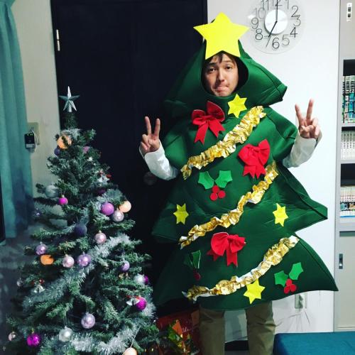 a man dressed in a christmas costume next to a christmas tree at OUCHI HOTEL Yokogawa in Hiroshima