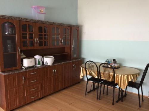 uma cozinha com mesa e cadeiras e um armário em Jauharee Homestay Muar Entire Home em Muar