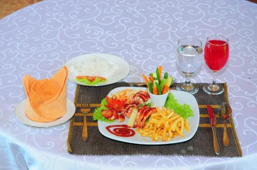 a table with two plates of food and rice at Hotel Sobana Lake front in Udawalawe