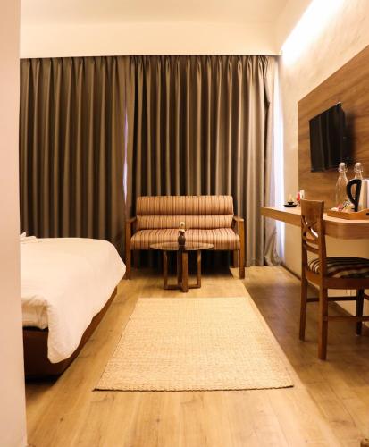 a bedroom with a bed and a chair and a table at Hotel Lumbini Garden New Crystal in Rummindei