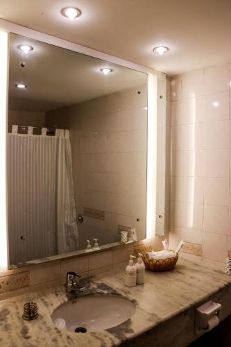 a bathroom with a sink and a large mirror at Hotel Lumbini Garden New Crystal in Rummindei