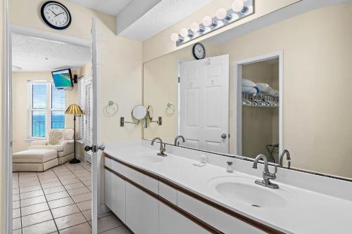 a bathroom with a sink and a mirror at The Palms #601 in Fort Walton Beach