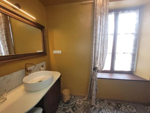 a bathroom with a sink and a mirror and a window at Maison d'hôtes Coeurdacier in Monthureux-sur-Saône