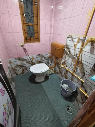 a bathroom with a toilet and a bucket in it at Jonaki Aalay-Cozy and Budget Stay-Ulubari in Guwahati
